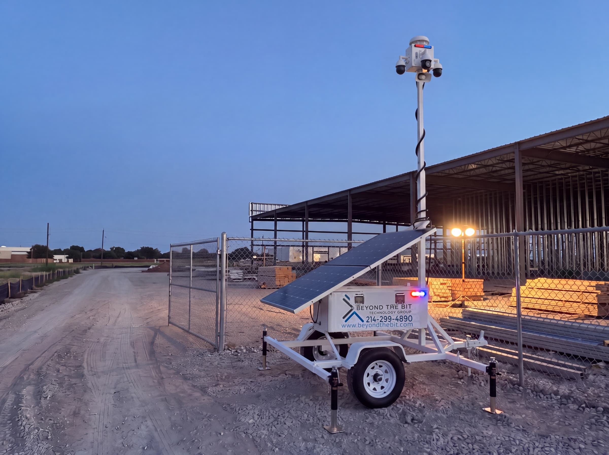 A security trailer parked at a jobsite gate at dusk, mast raised, ready to move to the next phase of the project.