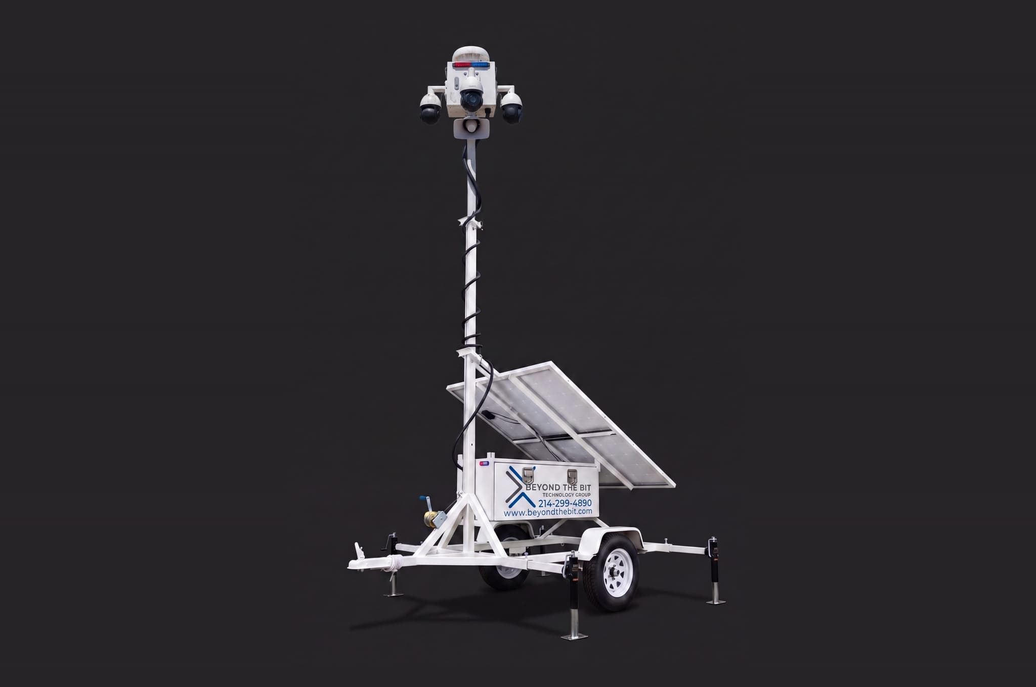 Studio view of a Beyond the Bit security trailer showing the raised camera mast, solar panels, and strobe against a dark background.